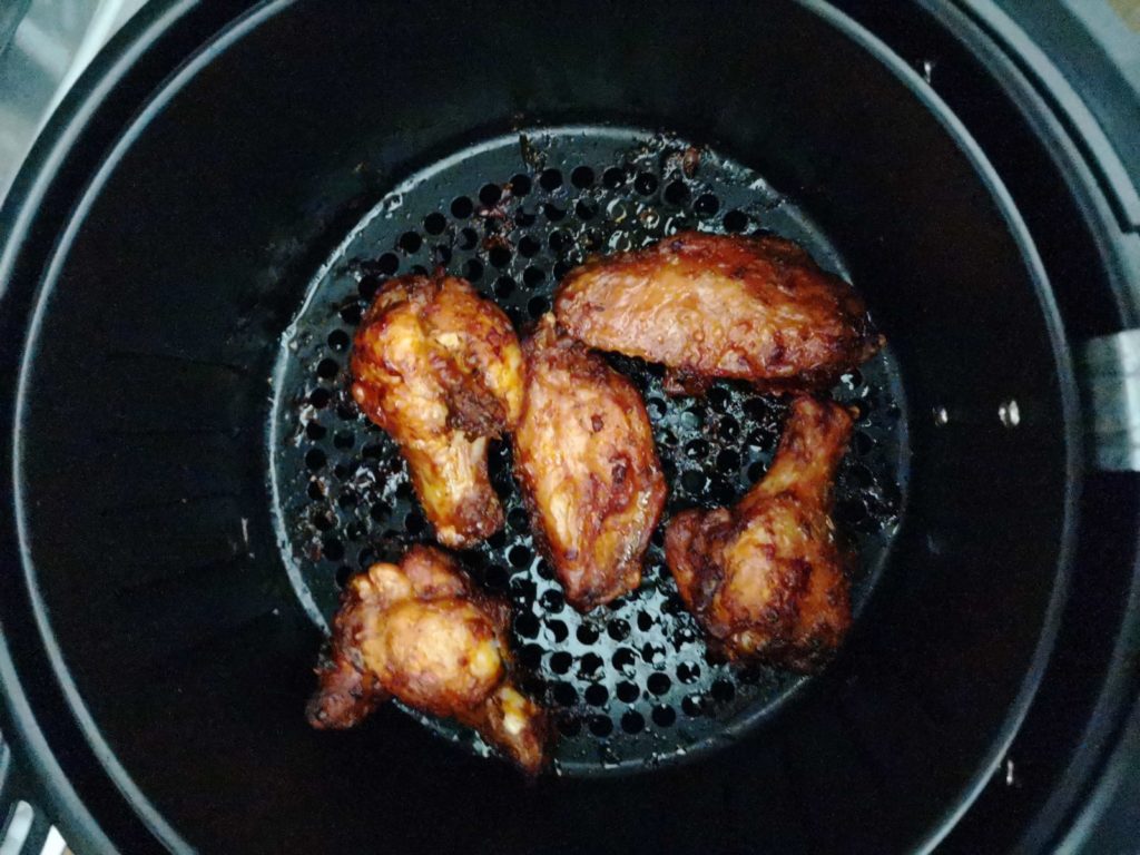 Rapeita kanan siipiä airfryer korissa.