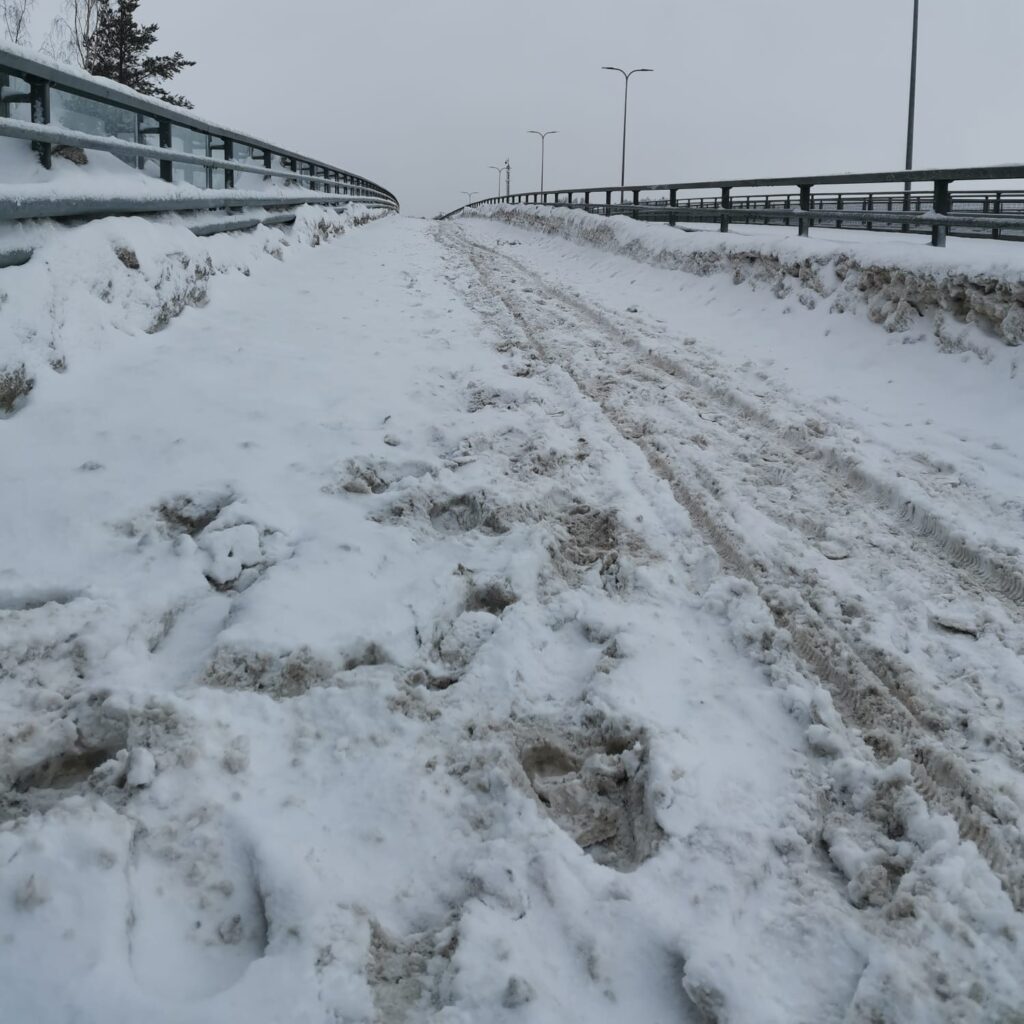 Tieltä on työnnetty kaikki sohjo jalkakäytävälle. Pieni polku vie eteenpäin.